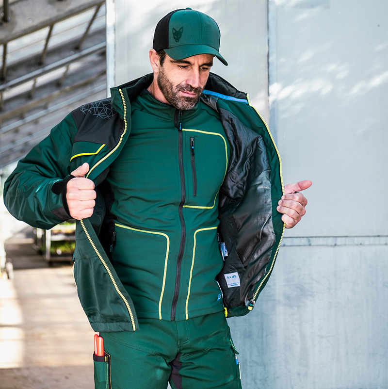 Ouvrier portant une veste d'hiver verte, une couche intermédiaire et une casquette de baseball